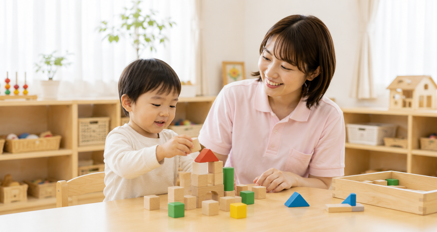 明るい教室で積み木に取り組む子どもと支援員